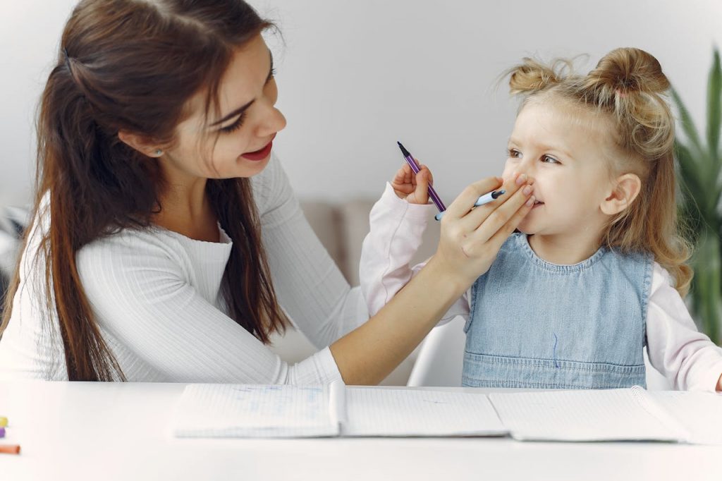 Petite fille qui fait du dessin avec sa nounou