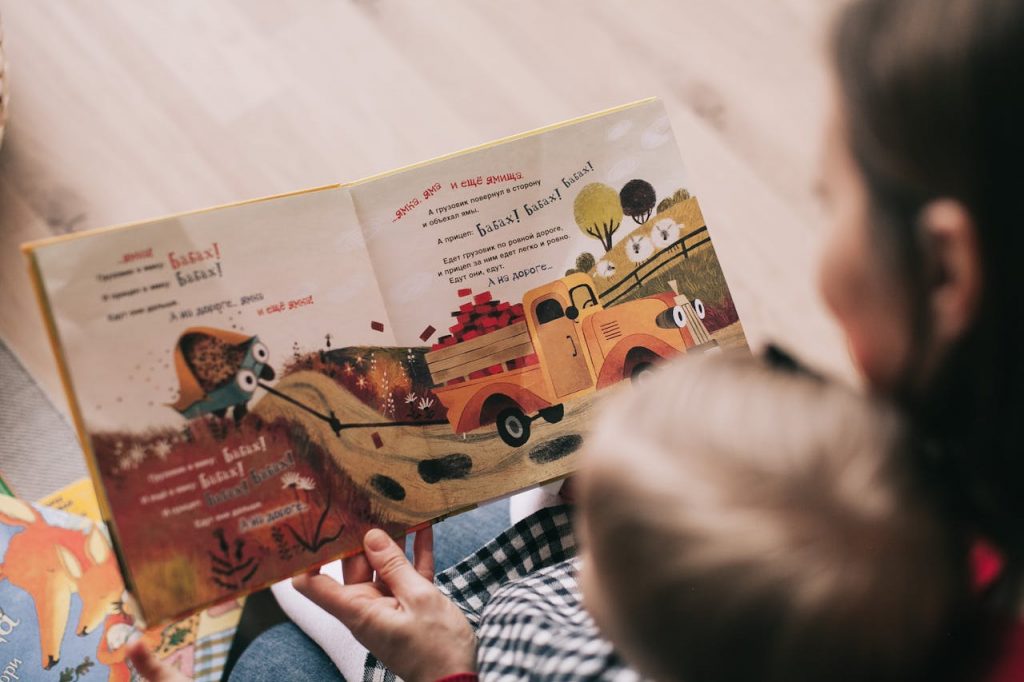 Enfant qui regarde un livre de contes avec sa nounou